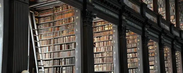 Büstler ve yüksek kitap raflarıyla tarihi kütüphane salonu